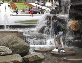 Kieron darts over the stepping stones at Ole Bull Fountain, Bergen